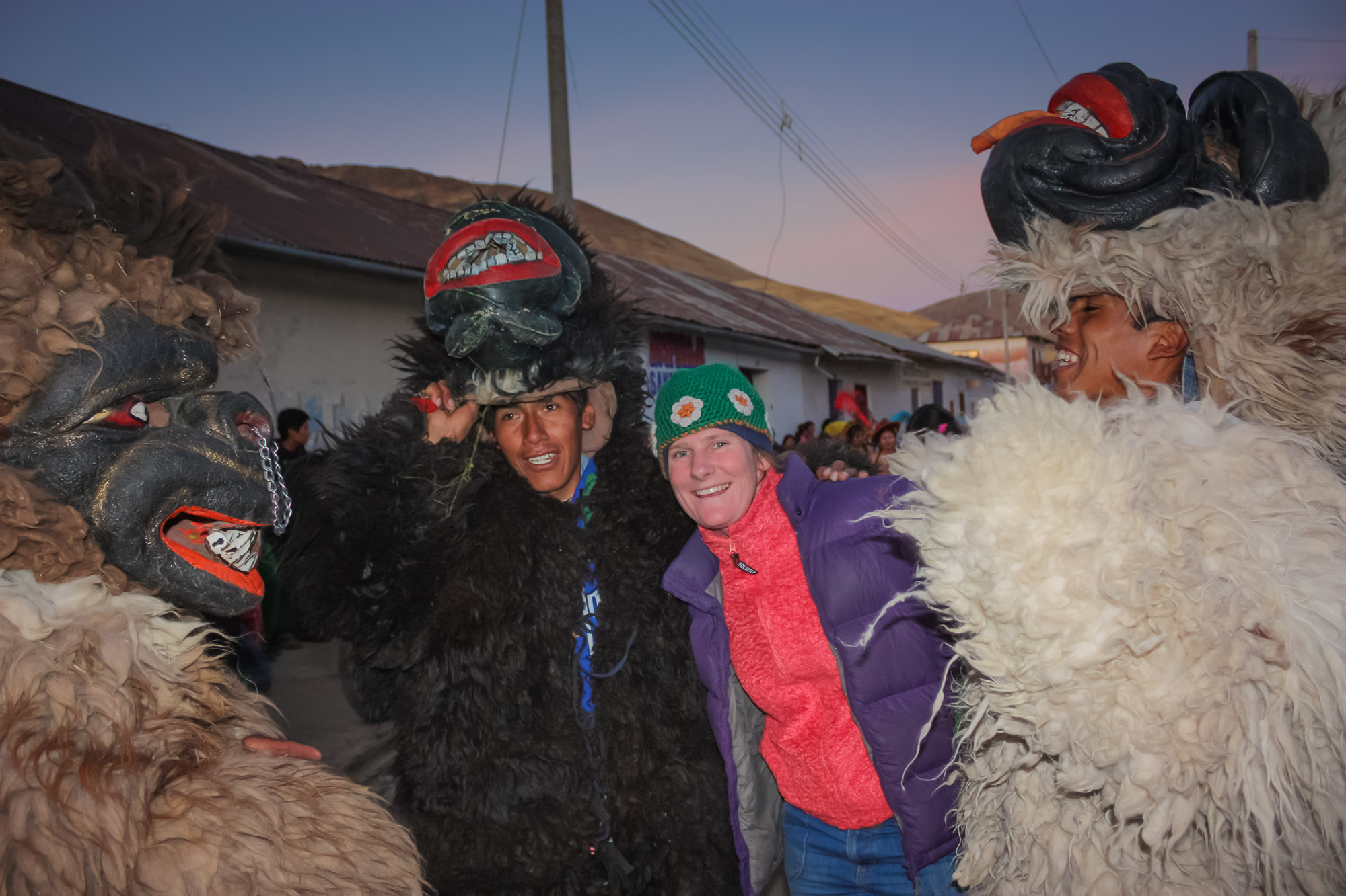 Guest on one of our Peru adventure tours embraced by three locals dressed as bears